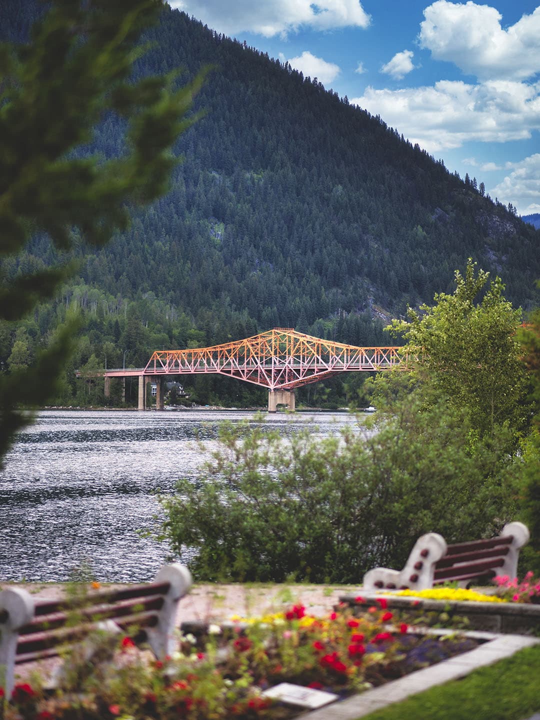 Nelson's orange bridge over the lake with mountains and gardens in the foreground.