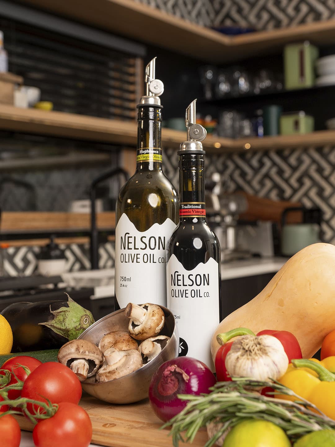 Olive oil being poured over fresh vegetables in a kitchen setting.