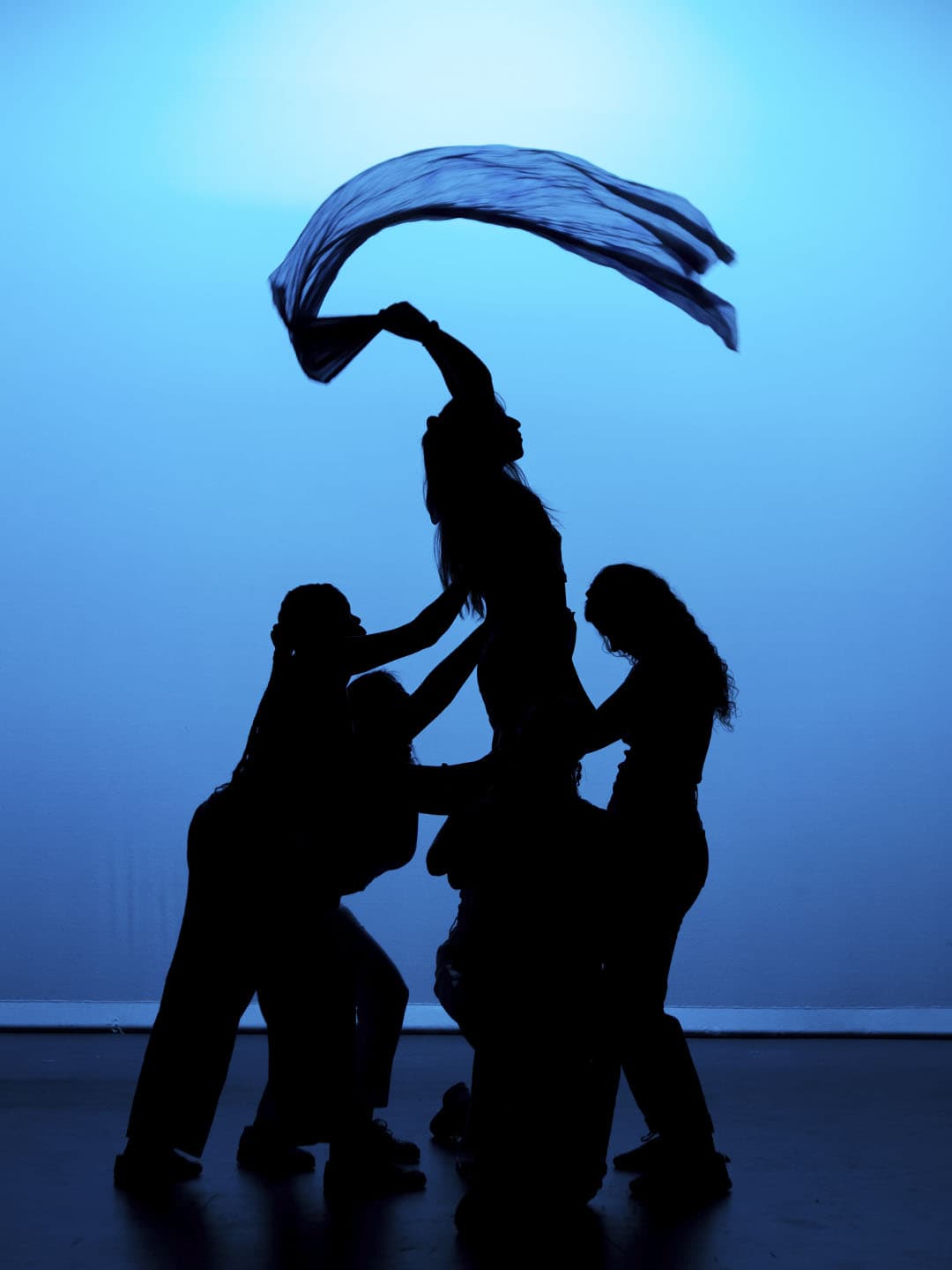 Traditional dancers performing on stage in vibrant blue and yellow costumes.